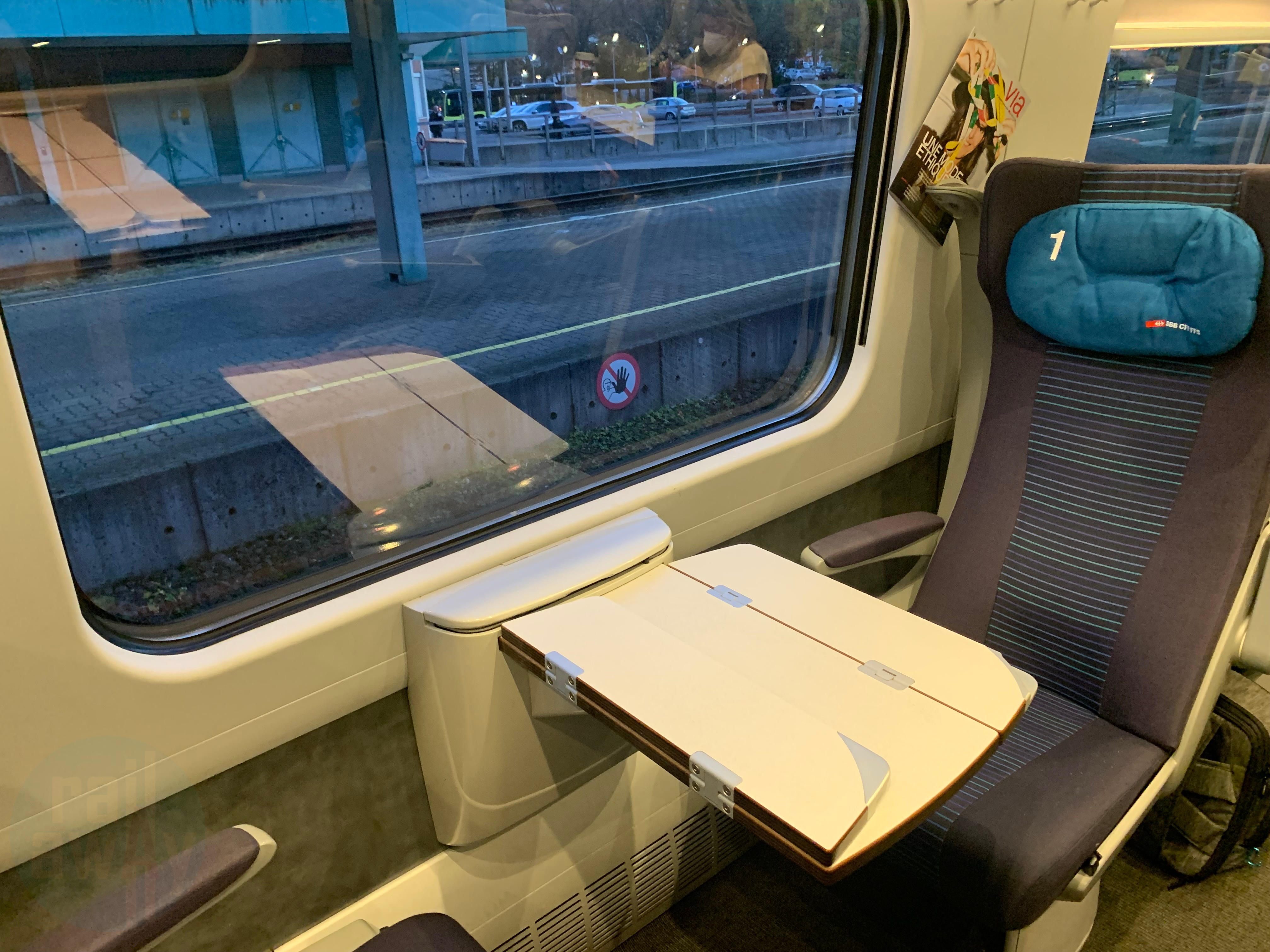 Blue and purple seats and grey carpet, 2 seats arranged one opposite the other with foldable table