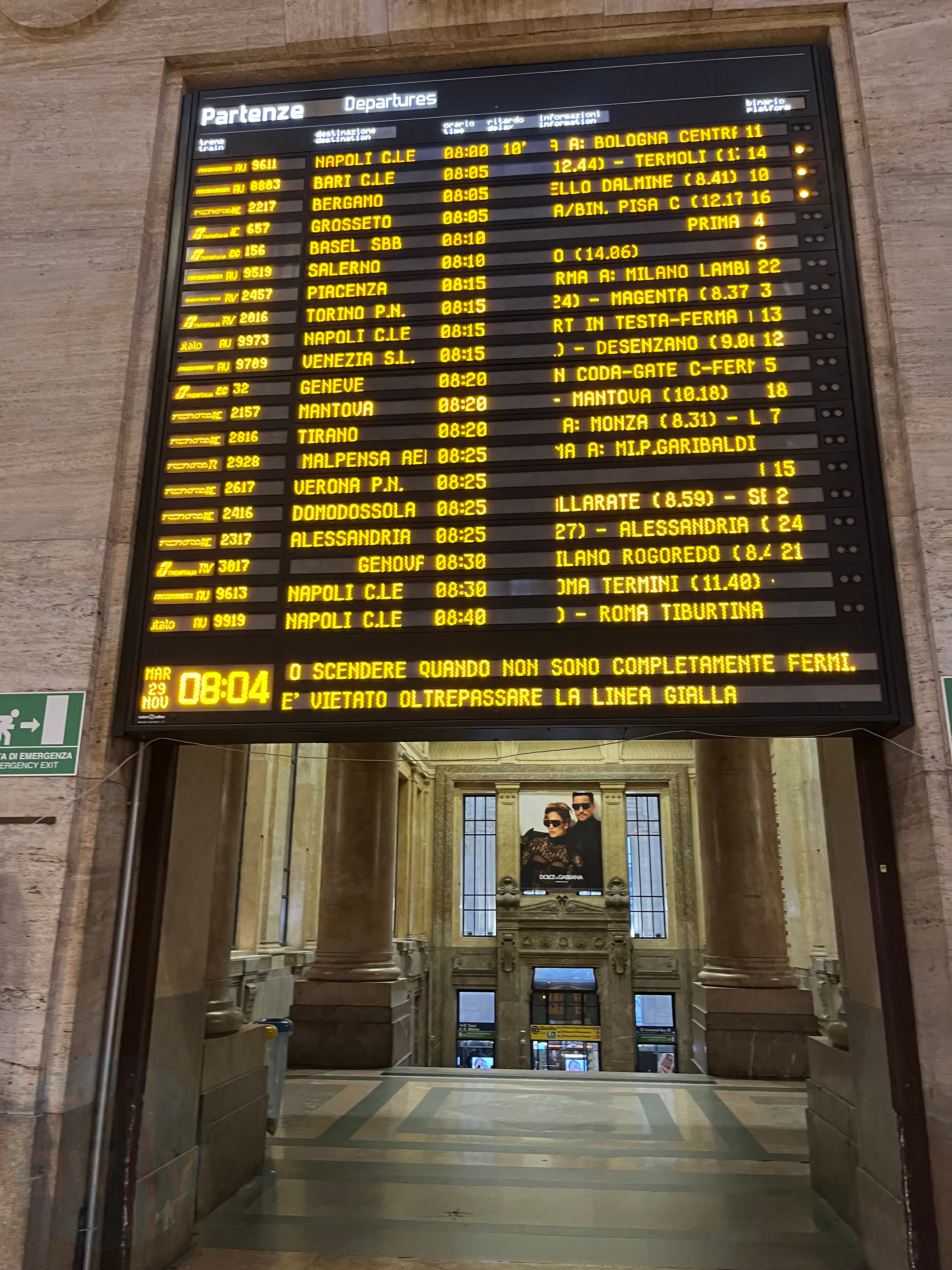 Departure board with yellow text on black background detailing left to right operator, train number, destination, departure time, the stations the train calls at with arrival times, and the platform for the train.