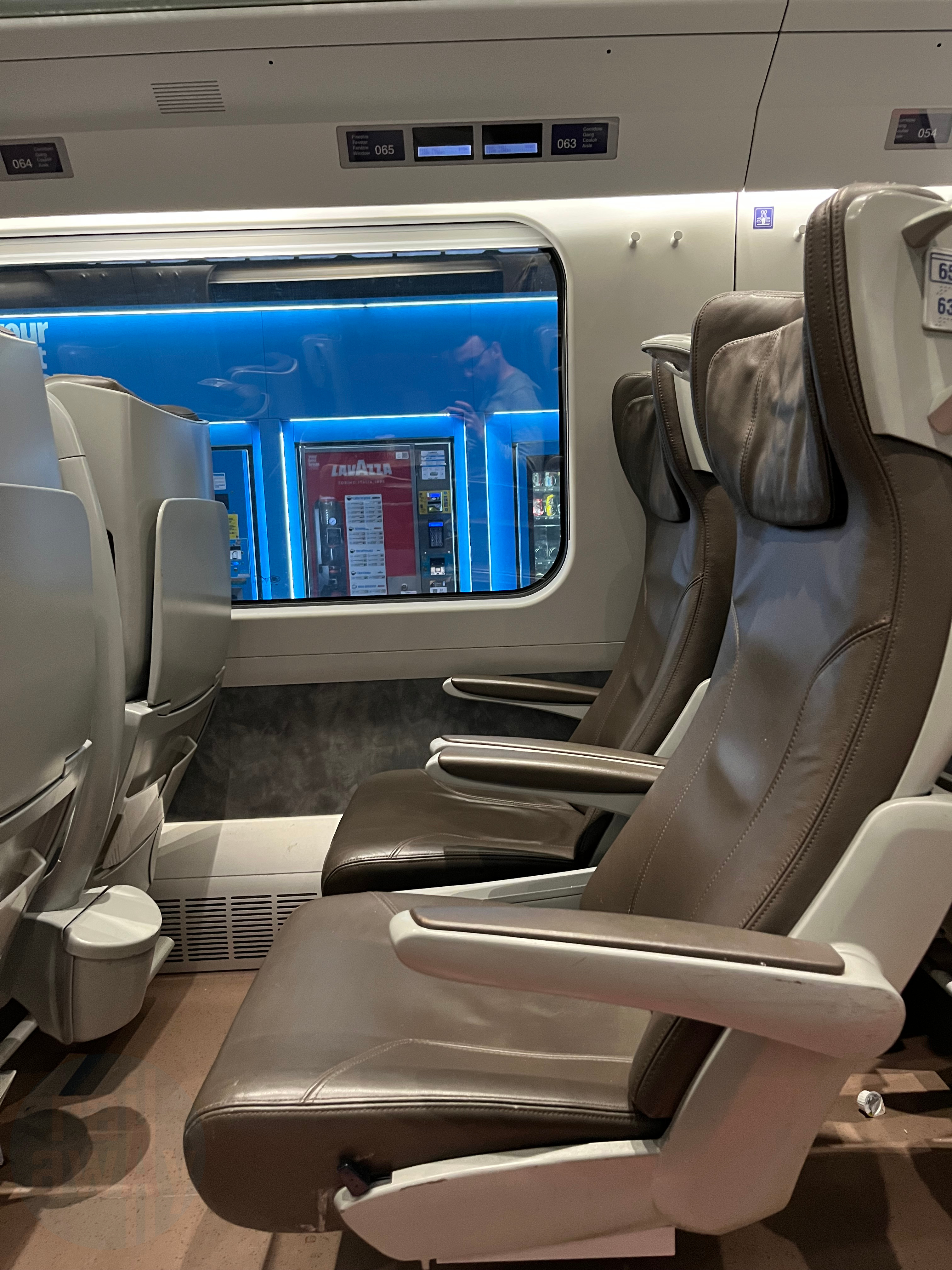 Two airline style brown leather seats in the First Class coach