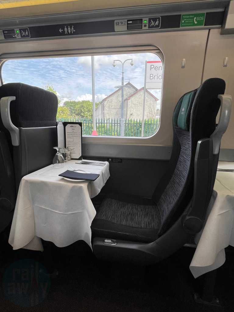 A solo seat onboard the GWR Pullman Dining carriage with tables ready for service with tablecloths, menus and cutlery