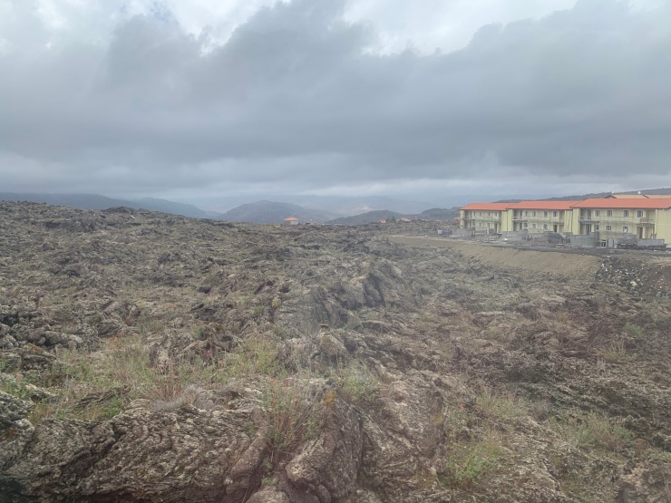 A view out of the window of the train with volcanic lava fields